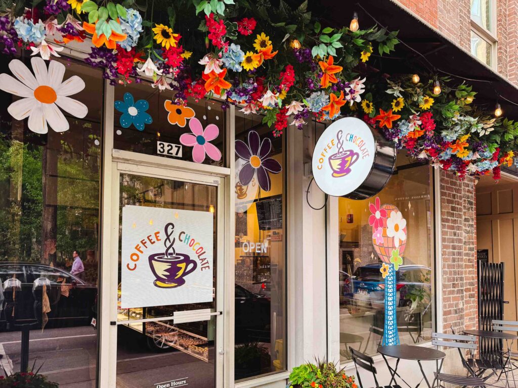 Downtown Coffee and Chocolate in Knoxville Tennessee exterior with flowers on the overhang and window painting of the Sunsphere
