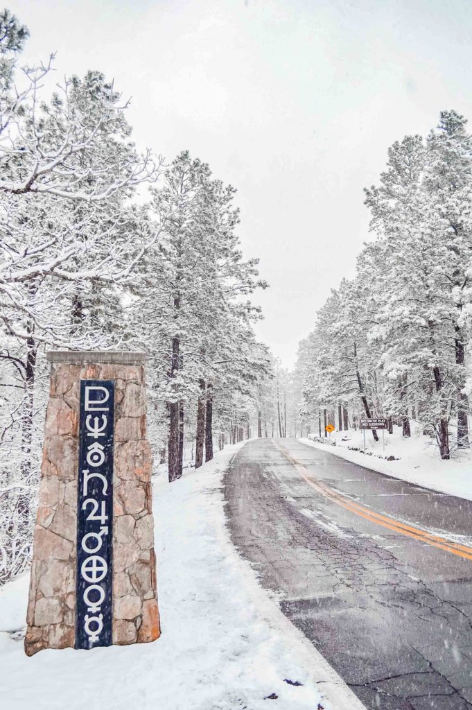 planet symbols on a pillar on the side of a road leading up to Lowell Observatory in Flagstaff during a snowy winter day